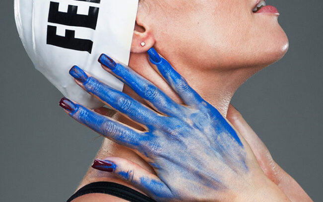 World swimming champion Federica Pellegrini photographed with blue hands and swimming cap by Gianluigi Di Napoli for a Charity project for AIPI Italia Onlus