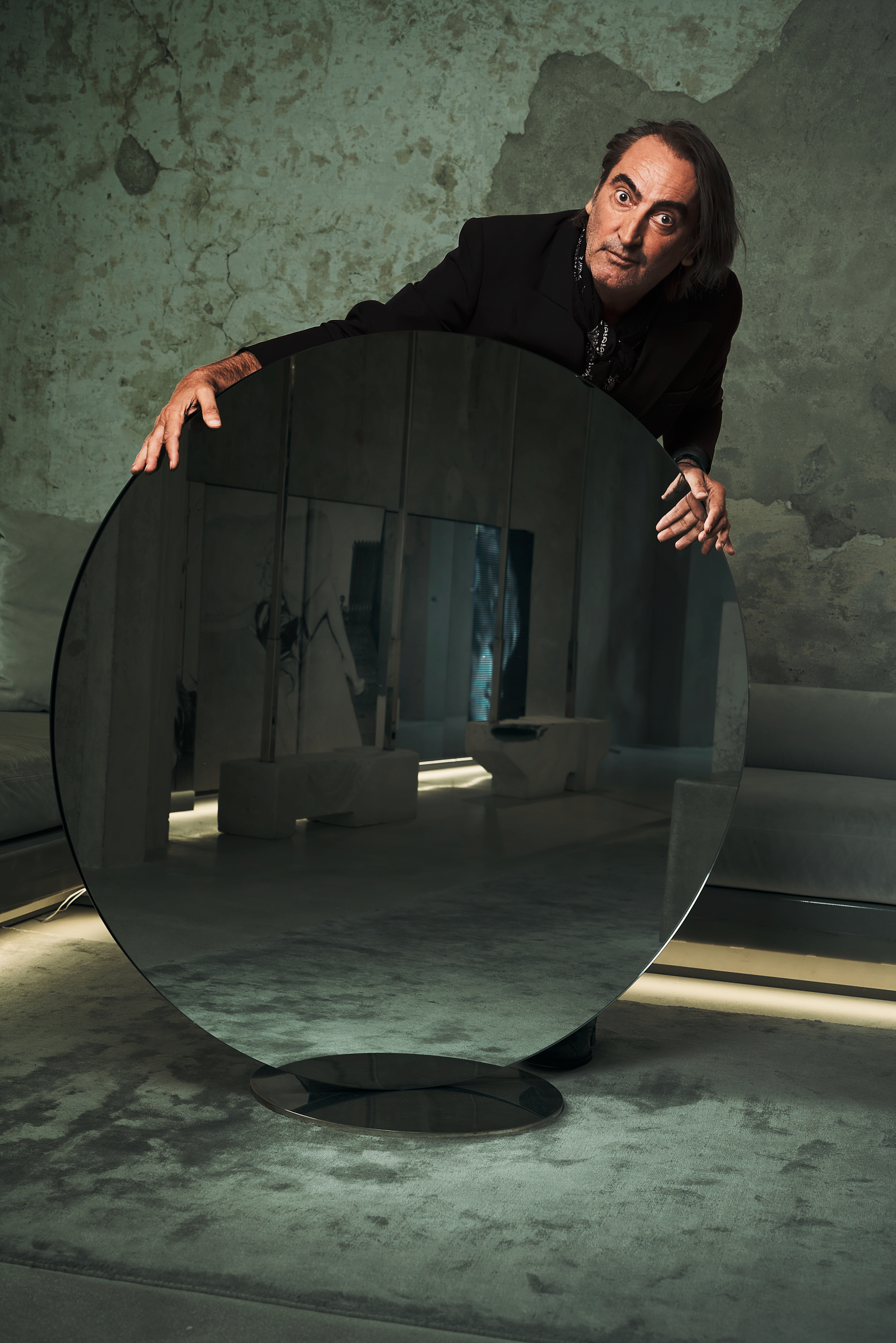 Uomo nel suo negozio dietro a specchio circolare. Beppe Angiolini. Ritratto colori di Gianluigi Di Napoli